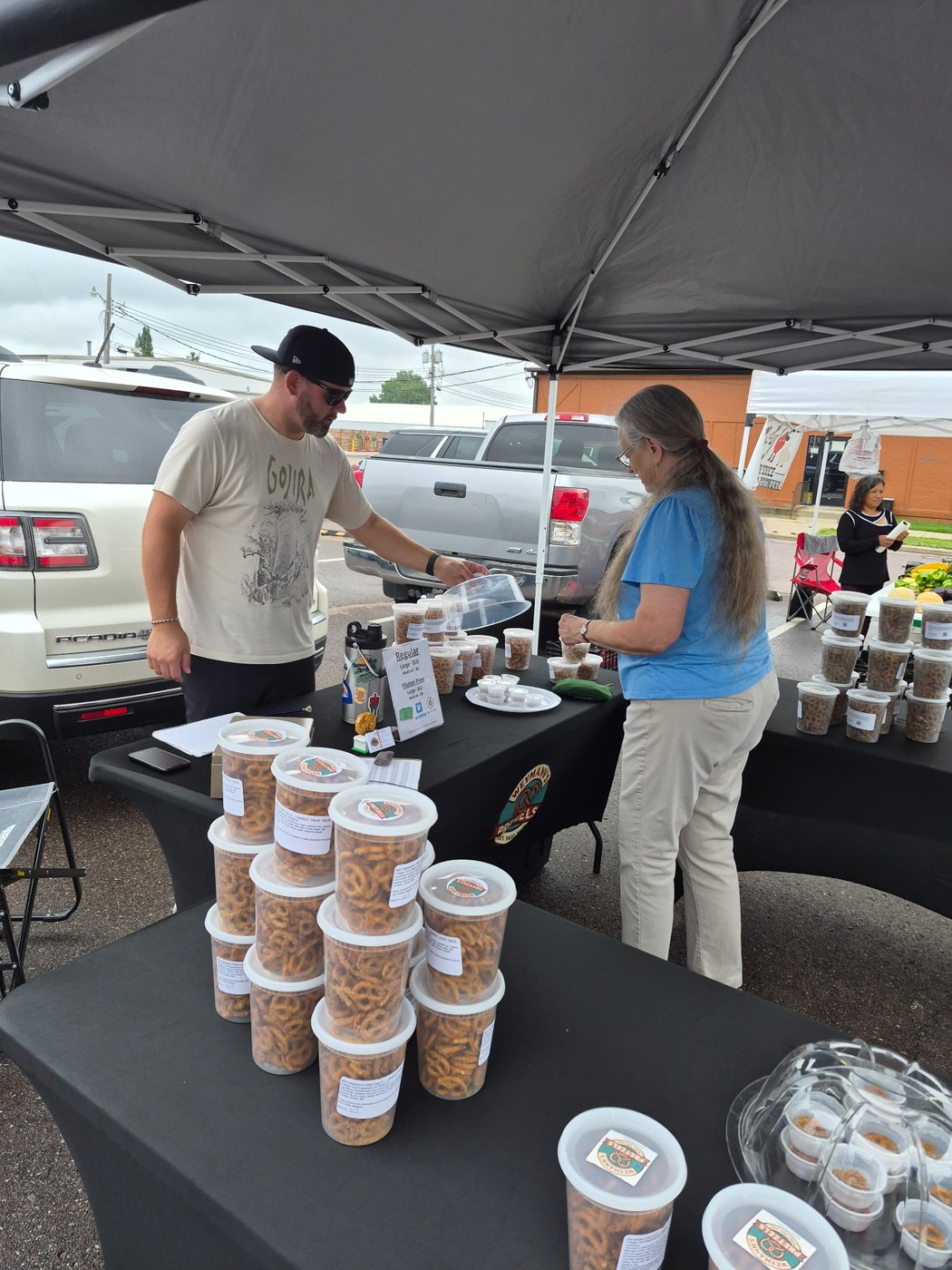 Chris Weymann helping a customer choose pretzels at a local market booth